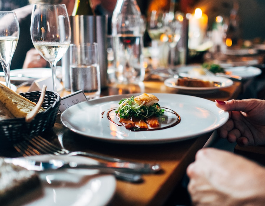 Chef presenting a plated dish at an elegant dinner table